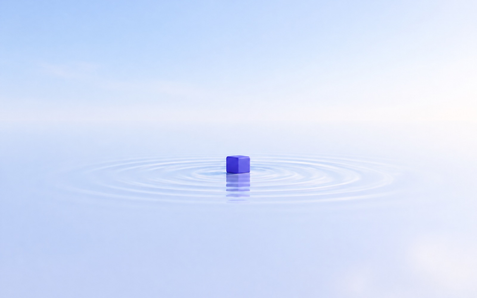 A lone indigo cube on a calm surface with faint ripples around it